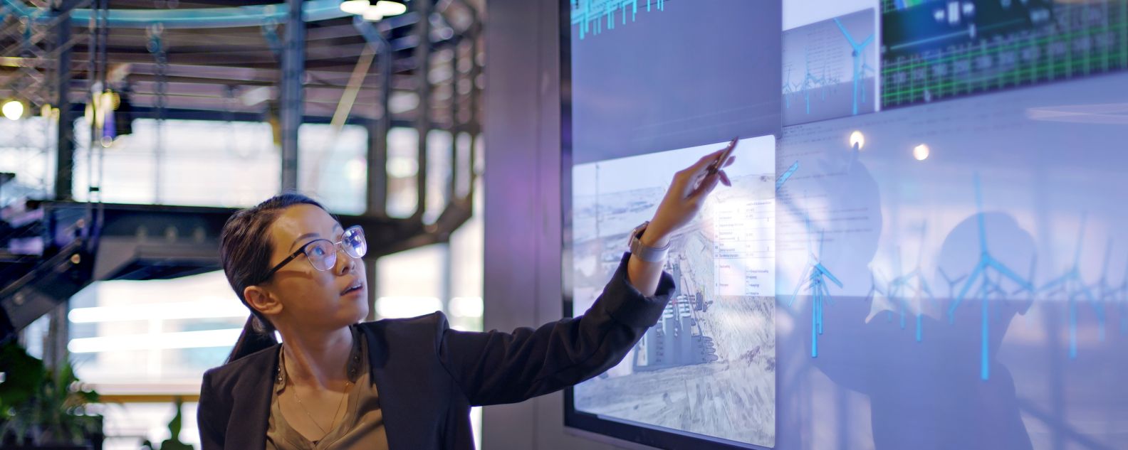 Woman pointing to charts on large screen