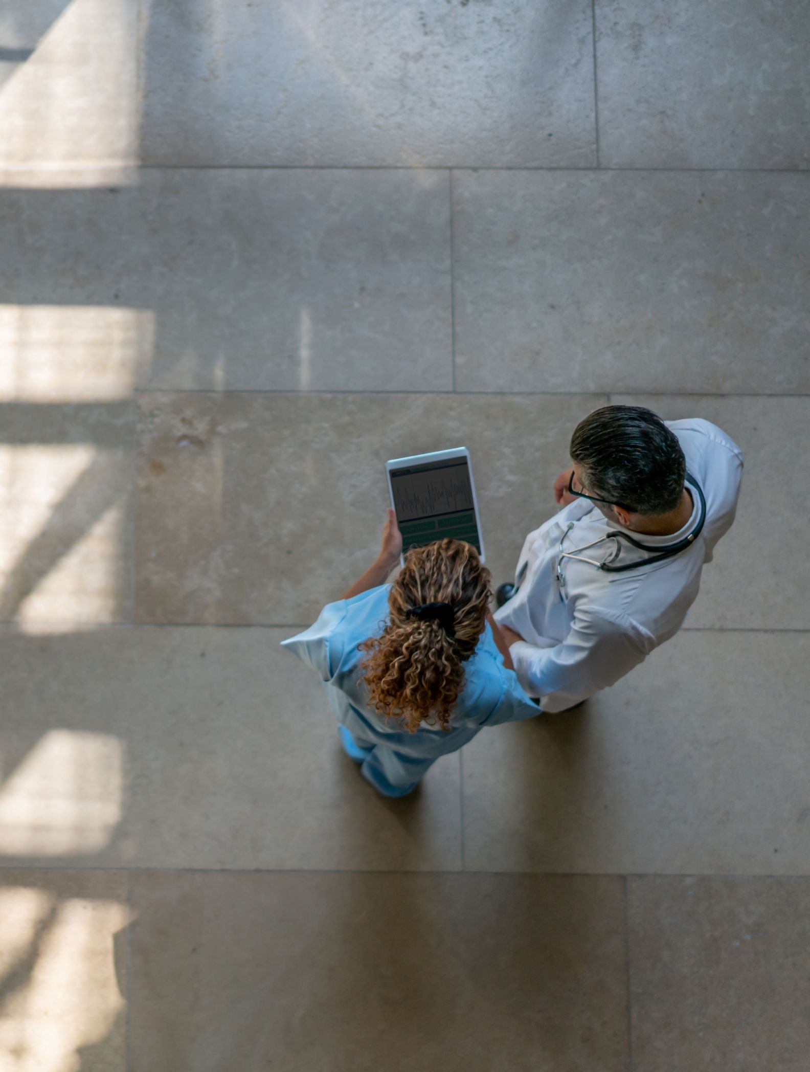 Overhead view of a woman and a man viewing a tablet