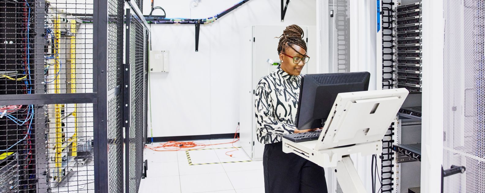  データセンターでサーバーの構成に取り組む女性IT担当者の画像