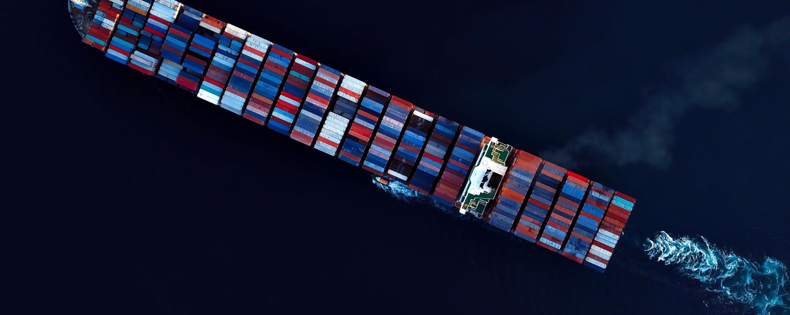Aerial view of cargo ship on the ocean carrying containers