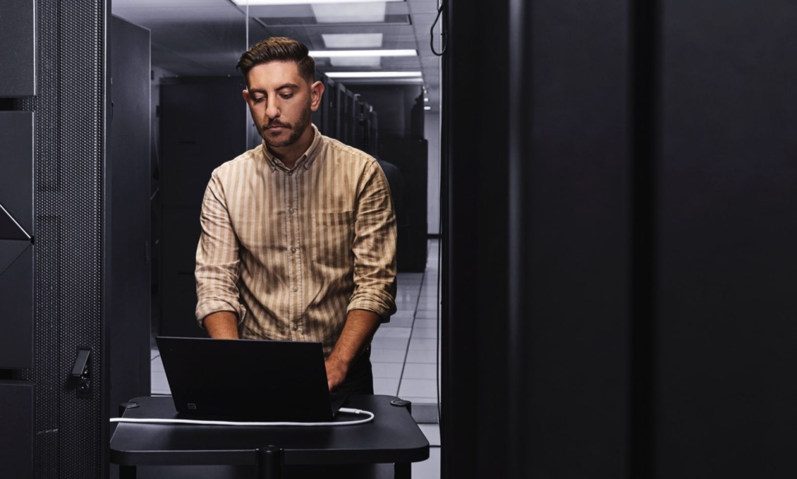 Male in server room on a laptop