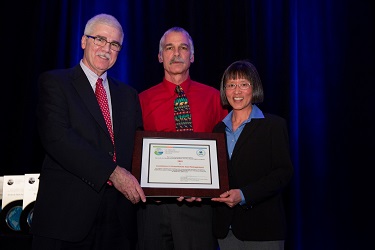 Dennis J. McLerran, EPA, presents the award to Jay Dietrich, Distinguished Engineer, energy and climate stewardship, IBM Corporate Environmental Affairs, and Edan Dionne, director, IBM Corporate Environmental Affairs