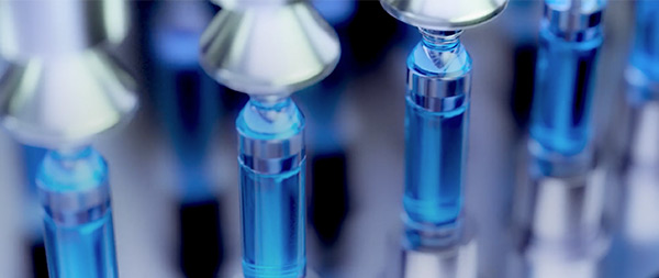 Four pharmaceutical vials on assembly line