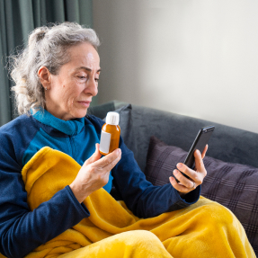 Elderly woman using phone to order prescription