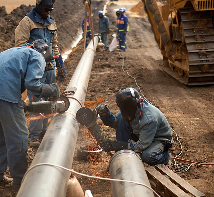 Workers installing large pipes at work site