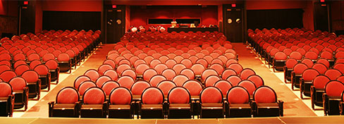 Rows of theater chairs with red cushions