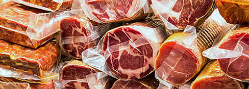 Meats stacked and wrapped in plastic
