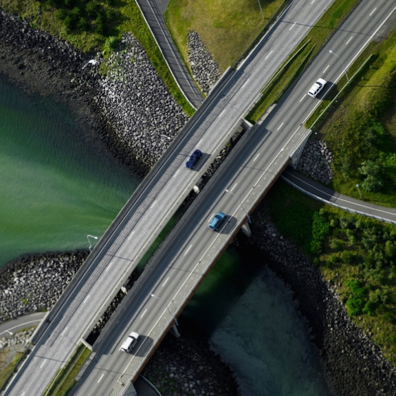 Aerial view of cars driving over a bridge.