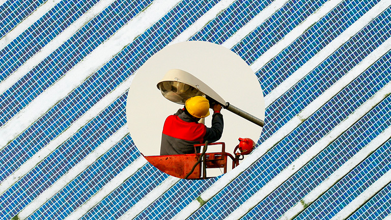 Uniformed worker repairing an electric power pole.