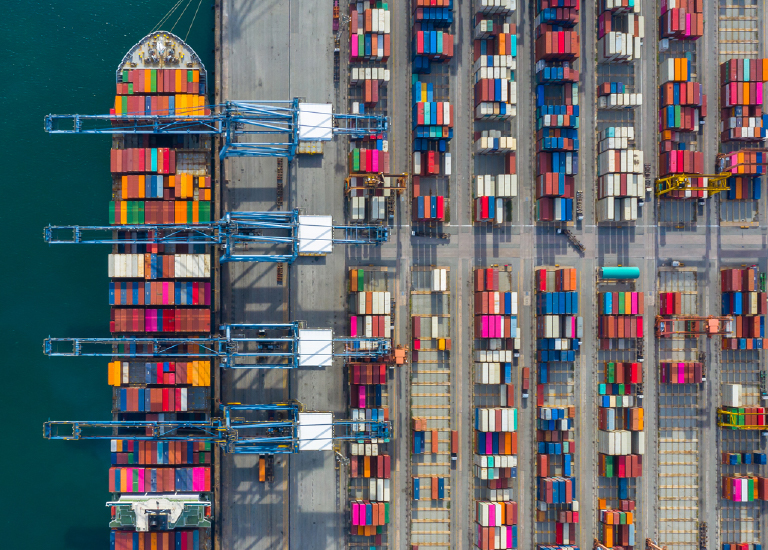 Aerial view of shipping containers on dock and ship