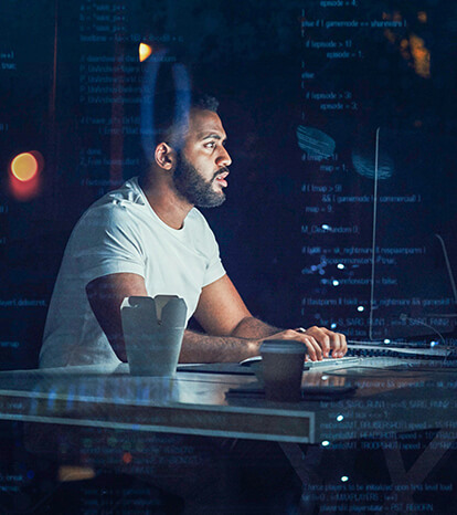 A young black male developer working late into the night inspecting and reviewing lines ofcode in his software application