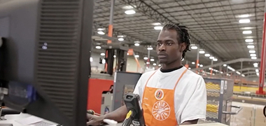 A Home Depot employee working at a computer.