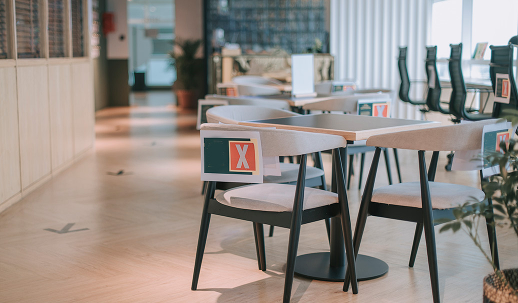 Empty tables and chairs in a cafe marked for social distancing